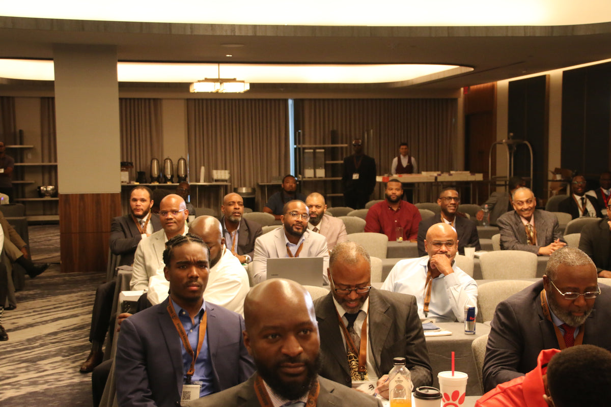 Black Manosphere Conclave attendees seated together during a conference session