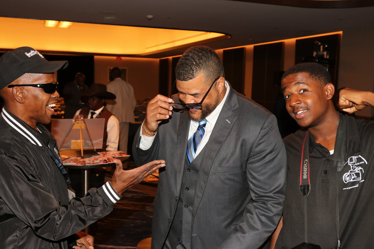 Two Black Manosphere Conclave attendees greeting each other with a handshake